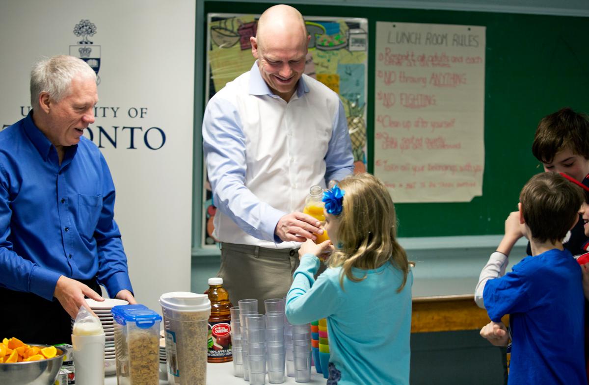 Dr. Stephen Lye (Left), Professor in the Departments of Obstetrics and Gynaecology and Physiology, and Mats Sundin serve a nutritious breakfast to elementary school students.