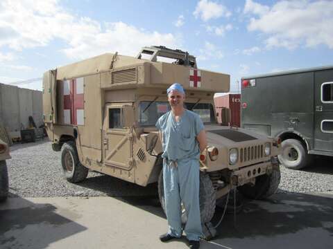 Dr. Andrew Beckett at Kandahar Airfield in front of Humvee ambulance