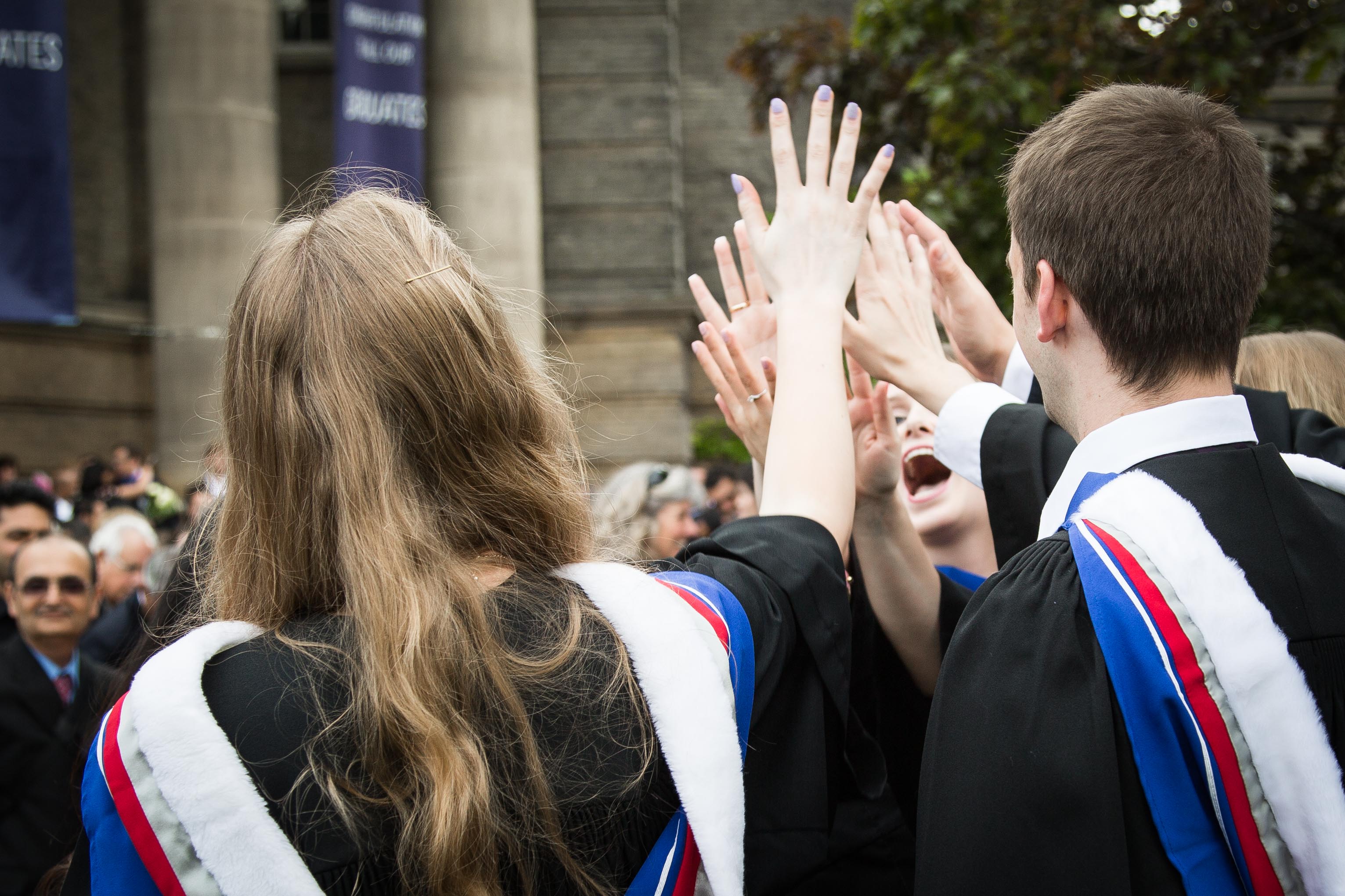 Students high five after graduating from the MD Program