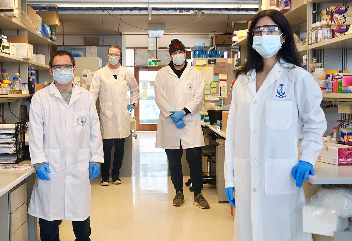 researchers in the lab wearing protective equipment and masks