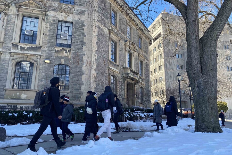 People walk outside the Naylor building on U of T's St. George campus on a winter day