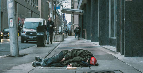 Homeless person sleeping on sidewalk 