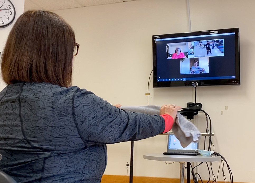 A woman leads a virtual rehabilitation class.